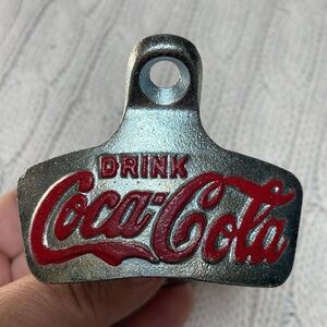 Metal Coca-Cola bottle open. Attaches to wall or cabinet w/ 2 screws. Red logo